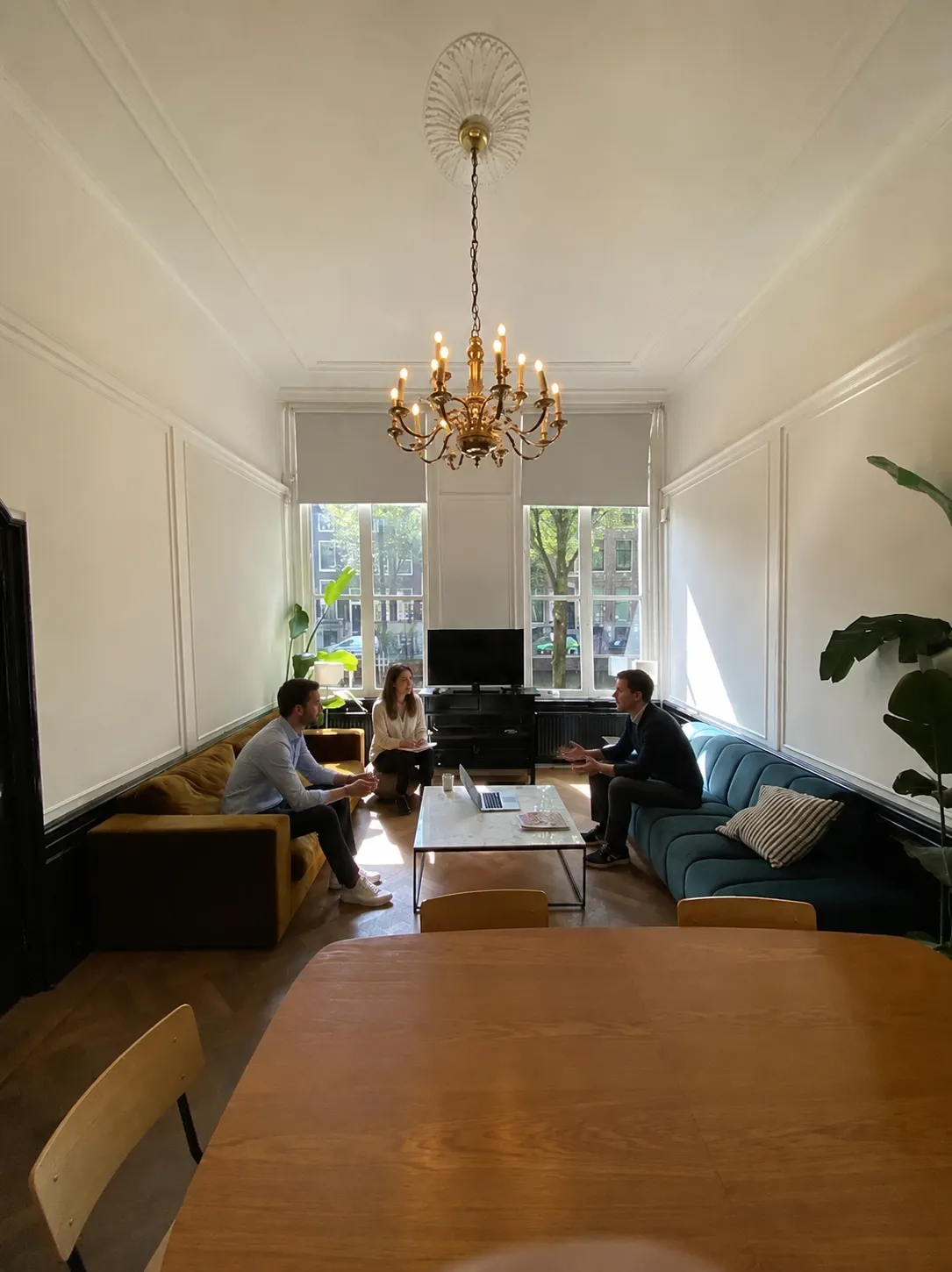 Three members of the Xeco Labs team in conversation in the office meeting room.